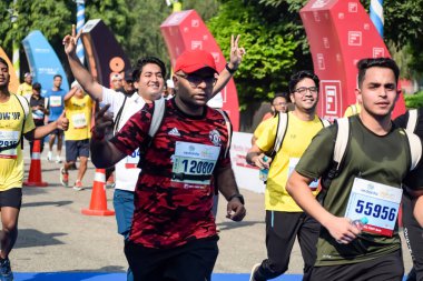 Yeni Delhi, Hindistan - 15 Ekim 2023 - Bitmek üzere olan maraton katılımcılarının bitiş çizgisini geçmek üzere olan Delhi Yarı Maratonu 2023