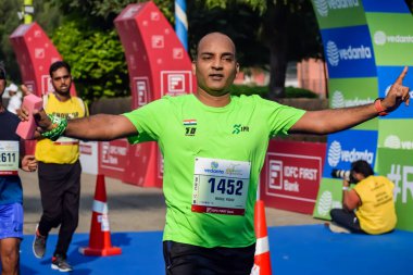 Yeni Delhi, Hindistan - 15 Ekim 2023 - Bitmek üzere olan maraton katılımcılarının bitiş çizgisini geçmek üzere olan Delhi Yarı Maratonu 2023