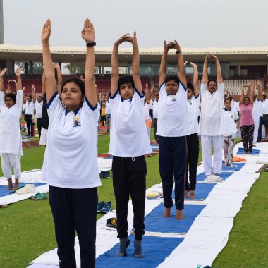 Yeni Delhi, Hindistan, 21 Haziran 2023 - Uluslararası Yoga Günü 'nde Delhi' deki Yamuna Spor Kompleksi 'nde grup Yoga egzersiz oturumu, kriket stadyumunda yoga derslerine katılan büyük bir grup yetişkin