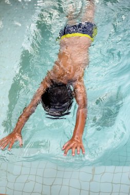 Havuzda yüzen mutlu Hintli çocuk, sıcak yaz tatillerinde hava tüpüyle birlikte yüzen çocuk, büyük bir havuzda yüzen çocuk..