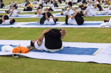 Yeni Delhi, Hindistan, 21 Haziran 2023 - Uluslararası Yoga Günü 'nde Delhi' deki Yamuna Spor Kompleksi 'nde grup Yoga egzersiz oturumu, kriket stadyumunda yoga derslerine katılan büyük bir grup yetişkin