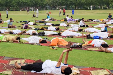 Yeni Delhi, Hindistan, 21 Haziran 2023 - Uluslararası Yoga Günü 'nde Delhi' deki Yamuna Spor Kompleksi 'nde grup Yoga egzersiz oturumu, kriket stadyumunda yoga derslerine katılan büyük bir grup yetişkin