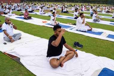 Yeni Delhi, Hindistan, 21 Haziran 2023 - Uluslararası Yoga Günü 'nde Delhi' deki Yamuna Spor Kompleksi 'nde grup Yoga egzersiz oturumu, kriket stadyumunda yoga derslerine katılan büyük bir grup yetişkin