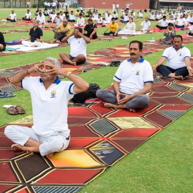 Yeni Delhi, Hindistan, 21 Haziran 2023 - Uluslararası Yoga Günü 'nde Delhi' deki Yamuna Spor Kompleksi 'nde grup Yoga egzersiz oturumu, kriket stadyumunda yoga derslerine katılan büyük bir grup yetişkin