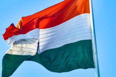 India flag flying high at Connaught Place with pride in blue sky, India flag fluttering, Indian Flag on Independence Day and Republic Day of India, tilt up shot, Waving Indian flag, Har Ghar Tiranga