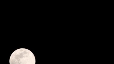 Moon Timelapse, Stock zamanaşımı: Dolunay karanlık gökyüzünde yükseliyor, gece vakti. Dolunay zamanı, gece karanlığında karanlık gökyüzünde ay ışığıyla birlikte kaybolur. Yüksek kaliteli beleş video kaydı veya zaman ayarlı