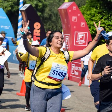 Yeni Delhi, Hindistan - 15 Ekim 2023 - Bitmek üzere olan maraton katılımcılarının bitiş çizgisini geçmek üzere olan Delhi Yarı Maratonu 2023