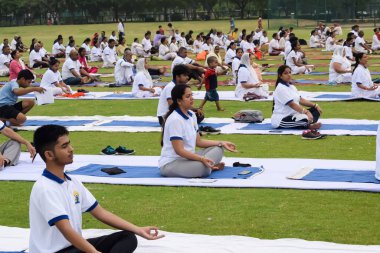 Yeni Delhi, Hindistan, 21 Haziran 2023 - Uluslararası Yoga Günü 'nde Delhi' deki Yamuna Spor Kompleksi 'nde grup Yoga egzersiz oturumu, kriket stadyumunda yoga derslerine katılan büyük bir grup yetişkin