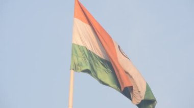 India flag flying high at Connaught Place with pride in blue sky, India flag fluttering, Indian Flag on Independence Day and Republic Day of India, tilt up shot, Waving Indian flag, Har Ghar Tiranga