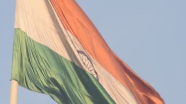 India flag flying high at Connaught Place with pride in blue sky, India flag fluttering, Indian Flag on Independence Day and Republic Day of India, tilt up shot, Waving Indian flag, Har Ghar Tiranga