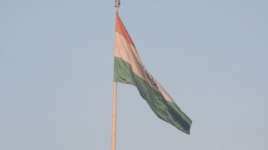 India flag flying high at Connaught Place with pride in blue sky, India flag fluttering, Indian Flag on Independence Day and Republic Day of India, tilt up shot, Waving Indian flag, Har Ghar Tiranga