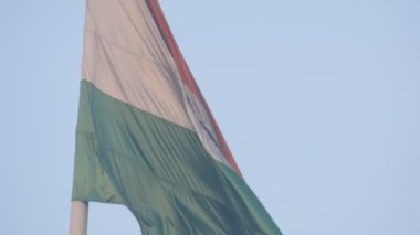 India flag flying high at Connaught Place with pride in blue sky, India flag fluttering, Indian Flag on Independence Day and Republic Day of India, tilt up shot, Waving Indian flag, Har Ghar Tiranga