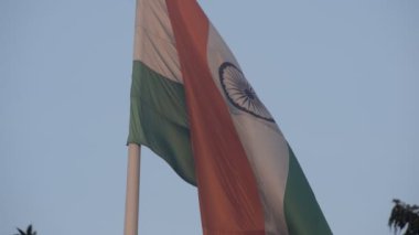 India flag flying high at Connaught Place with pride in blue sky, India flag fluttering, Indian Flag on Independence Day and Republic Day of India, tilt up shot, Waving Indian flag, Har Ghar Tiranga