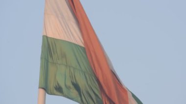 India flag flying high at Connaught Place with pride in blue sky, India flag fluttering, Indian Flag on Independence Day and Republic Day of India, tilt up shot, Waving Indian flag, Har Ghar Tiranga