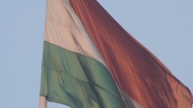 India flag flying high at Connaught Place with pride in blue sky, India flag fluttering, Indian Flag on Independence Day and Republic Day of India, tilt up shot, Waving Indian flag, Har Ghar Tiranga