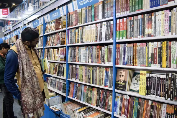 Delhi, Hindistan, 17 Şubat 2024 - Çeşitli yaş gruplarından insanlar Delhi Uluslararası Kitap Fuarı 'ndaki bir kitapçıda çeşitli kitaplar okuyor, Bharat Mandapam kompleksindeki Yıllık Kitap Fuarı' nda kitaplar