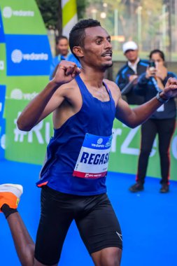 Yeni Delhi, Hindistan - 15 Ekim 2023 - Bitmek üzere olan maraton katılımcılarının bitiş çizgisini geçmek üzere olan Delhi Yarı Maratonu 2023