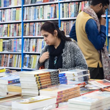 Delhi, Hindistan, 17 Şubat 2024 - Çeşitli yaş gruplarından insanlar Delhi Uluslararası Kitap Fuarı 'ndaki bir kitapçıda çeşitli kitaplar okuyor, Bharat Mandapam kompleksindeki Yıllık Kitap Fuarı' nda kitaplar