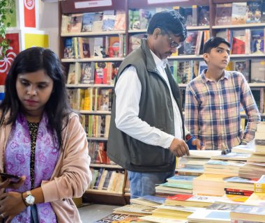 Delhi, Hindistan, 17 Şubat 2024 - Çeşitli yaş gruplarından insanlar Delhi Uluslararası Kitap Fuarı 'ndaki bir kitapçıda çeşitli kitaplar okuyor, Bharat Mandapam kompleksindeki Yıllık Kitap Fuarı' nda kitaplar