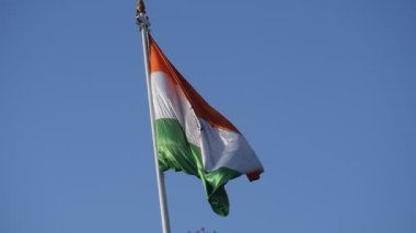 India flag flying high at Connaught Place with pride in blue sky, India flag fluttering, Indian Flag on Independence Day and Republic Day of India, tilt up shot, Waving Indian flag, Har Ghar Tiranga