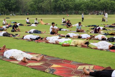 Yeni Delhi, Hindistan, 21 Haziran 2023 - Uluslararası Yoga Günü 'nde Delhi' deki Yamuna Spor Kompleksi 'nde grup Yoga egzersiz oturumu, kriket stadyumunda yoga derslerine katılan büyük bir grup yetişkin