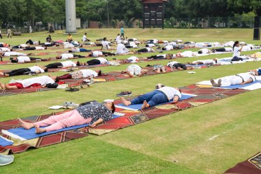 Yeni Delhi, Hindistan, 21 Haziran 2023 - Uluslararası Yoga Günü 'nde Delhi' deki Yamuna Spor Kompleksi 'nde grup Yoga egzersiz oturumu, kriket stadyumunda yoga derslerine katılan büyük bir grup yetişkin