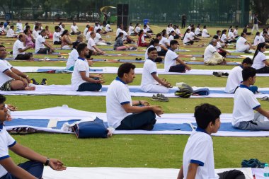 Yeni Delhi, Hindistan, 21 Haziran 2023 - Uluslararası Yoga Günü 'nde Delhi' deki Yamuna Spor Kompleksi 'nde grup Yoga egzersiz oturumu, kriket stadyumunda yoga derslerine katılan büyük bir grup yetişkin