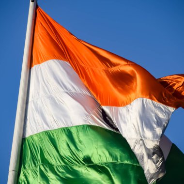 India flag flying high at Connaught Place with pride in blue sky, India flag fluttering, Indian Flag on Independence Day and Republic Day of India, tilt up shot, Waving Indian flag, Har Ghar Tiranga