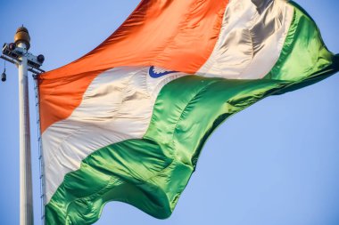 India flag flying high at Connaught Place with pride in blue sky, India flag fluttering, Indian Flag on Independence Day and Republic Day of India, tilt up shot, Waving Indian flag, Har Ghar Tiranga