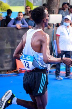 Yeni Delhi, Hindistan - 15 Ekim 2023 - Bitmek üzere olan maraton katılımcılarının bitiş çizgisini geçmek üzere olan Delhi Yarı Maratonu 2023