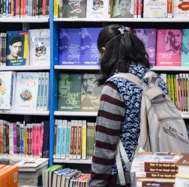 Delhi, Hindistan, 17 Şubat 2024 - Çeşitli yaş gruplarından insanlar Delhi Uluslararası Kitap Fuarı 'ndaki bir kitapçıda çeşitli kitaplar okuyor, Bharat Mandapam kompleksindeki Yıllık Kitap Fuarı' nda kitaplar