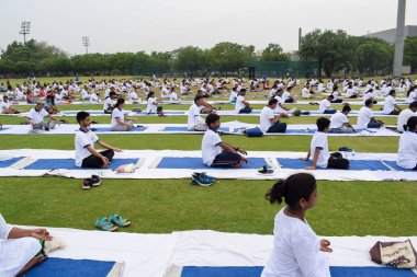 Yeni Delhi, Hindistan, 21 Haziran 2023 - Uluslararası Yoga Günü 'nde Delhi' deki Yamuna Spor Kompleksi 'nde grup Yoga egzersiz oturumu, kriket stadyumunda yoga derslerine katılan büyük bir grup yetişkin