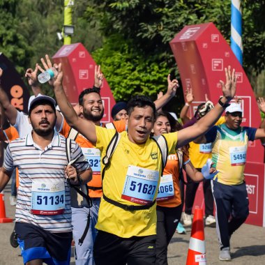 Yeni Delhi, Hindistan - 15 Ekim 2023 - Bitmek üzere olan maraton katılımcılarının bitiş çizgisini geçmek üzere olan Delhi Yarı Maratonu 2023