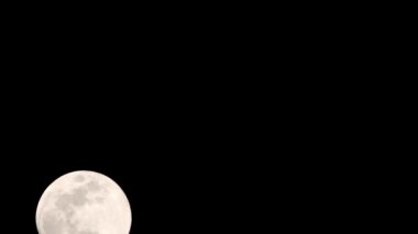 Moon Timelapse, Stock zamanaşımı: Dolunay karanlık gökyüzünde yükseliyor, gece vakti. Dolunay zamanı, gece karanlığında karanlık gökyüzünde ay ışığıyla birlikte kaybolur. Yüksek kaliteli beleş video kaydı veya zaman ayarlı