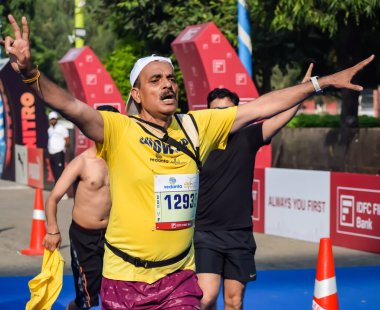 Yeni Delhi, Hindistan - 15 Ekim 2023 - Bitmek üzere olan maraton katılımcılarının bitiş çizgisini geçmek üzere olan Delhi Yarı Maratonu 2023