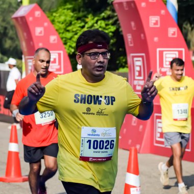 Yeni Delhi, Hindistan - 15 Ekim 2023 - Bitmek üzere olan maraton katılımcılarının bitiş çizgisini geçmek üzere olan Delhi Yarı Maratonu 2023