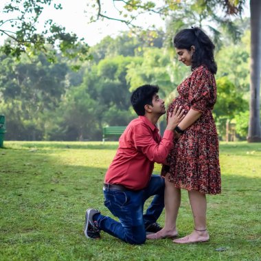 Hintli çift doğum çekimi için poz veriyor. Delhi 'deki Lodhi Garden' da yeni doğan bebeğe kucak açıyorlar. Anne ve babalar çocuklarını karşıladıkları için annelik fotoğrafı çekiyorlar.