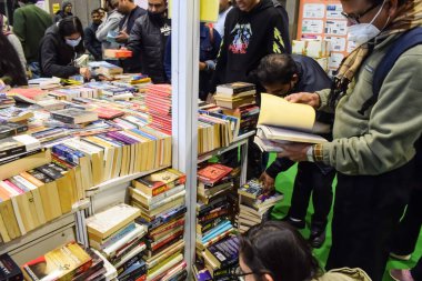 Delhi, Hindistan, 17 Şubat 2024 - Çeşitli yaş gruplarından insanlar Delhi Uluslararası Kitap Fuarı 'ndaki bir kitapçıda çeşitli kitaplar okuyor, Bharat Mandapam kompleksindeki Yıllık Kitap Fuarı' nda kitaplar