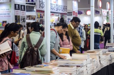 Delhi, Hindistan, 17 Şubat 2024 - Çeşitli yaş gruplarından insanlar Delhi Uluslararası Kitap Fuarı 'ndaki bir kitapçıda çeşitli kitaplar okuyor, Bharat Mandapam kompleksindeki Yıllık Kitap Fuarı' nda kitaplar