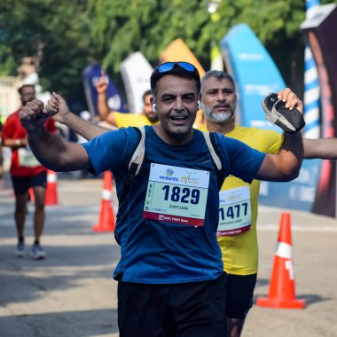 Yeni Delhi, Hindistan - 15 Ekim 2023 - Bitmek üzere olan maraton katılımcılarının bitiş çizgisini geçmek üzere olan Delhi Yarı Maratonu 2023