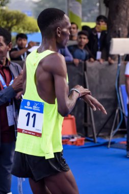 Yeni Delhi, Hindistan - 15 Ekim 2023 - Bitmek üzere olan maraton katılımcılarının bitiş çizgisini geçmek üzere olan Delhi Yarı Maratonu 2023