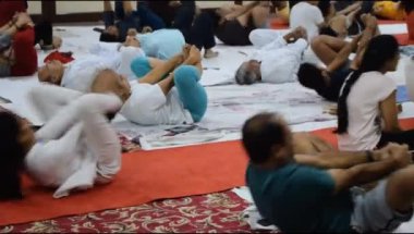 Yeni Delhi, Hindistan, 19 Nisan 2024 - Balaji Tapınağı, Vivek Vihar, Uluslararası Yoga Günü, tapınaktaki yoga sınıfına katılan büyük bir grup yetişkin için grup yoga oturumu