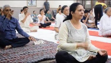 Yeni Delhi, Hindistan, 19 Nisan 2024 - Balaji Tapınağı, Vivek Vihar, Uluslararası Yoga Günü, tapınaktaki yoga sınıfına katılan büyük bir grup yetişkin için grup yoga oturumu