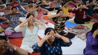 Yeni Delhi, Hindistan, 19 Nisan 2024 - Balaji Tapınağı, Vivek Vihar, Uluslararası Yoga Günü, tapınaktaki yoga sınıfına katılan büyük bir grup yetişkin için grup yoga oturumu