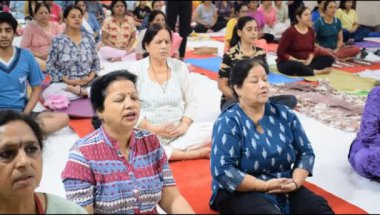 Yeni Delhi, Hindistan, 19 Nisan 2024 - Balaji Tapınağı, Vivek Vihar, Uluslararası Yoga Günü, tapınaktaki yoga sınıfına katılan büyük bir grup yetişkin için grup yoga oturumu