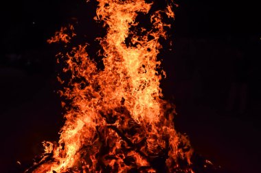 Siyah arka planda alevler, alev alev dokusu arka planda, çok güzel, ateş yanıyor, ateş odun ve inek gübresi ateşiyle yanıyor.