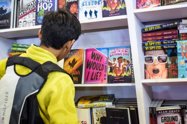 Delhi, Hindistan, 17 Şubat 2024 - Çeşitli yaş gruplarından insanlar Delhi Uluslararası Kitap Fuarı 'ndaki bir kitapçıda çeşitli kitaplar okuyor, Bharat Mandapam kompleksindeki Yıllık Kitap Fuarı' nda kitaplar