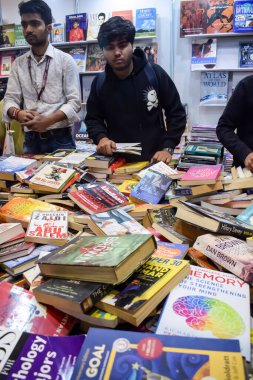 Delhi, Hindistan, 17 Şubat 2024 - Çeşitli yaş gruplarından insanlar Delhi Uluslararası Kitap Fuarı 'ndaki bir kitapçıda çeşitli kitaplar okuyor, Bharat Mandapam kompleksindeki Yıllık Kitap Fuarı' nda kitaplar