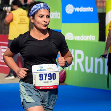 Yeni Delhi, Hindistan - 15 Ekim 2023 - Bitmek üzere olan maraton katılımcılarının bitiş çizgisini geçmek üzere olan Delhi Yarı Maratonu 2023