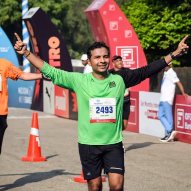 Yeni Delhi, Hindistan - 15 Ekim 2023 - Bitmek üzere olan maraton katılımcılarının bitiş çizgisini geçmek üzere olan Delhi Yarı Maratonu 2023